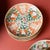 This petite porcelain dish from the mid-19th century is hand-painted with red & green overglaze enamels in the famille...