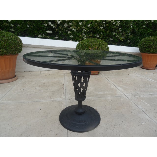 A rare wrought Iron Table from the 1970s with a glass top by luxury furniture maker Woodard Outdoor. Unmarked.