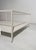 A rectangular coffee table with a minimalist and elegant design, featuring a simple white painted metal frame and two...