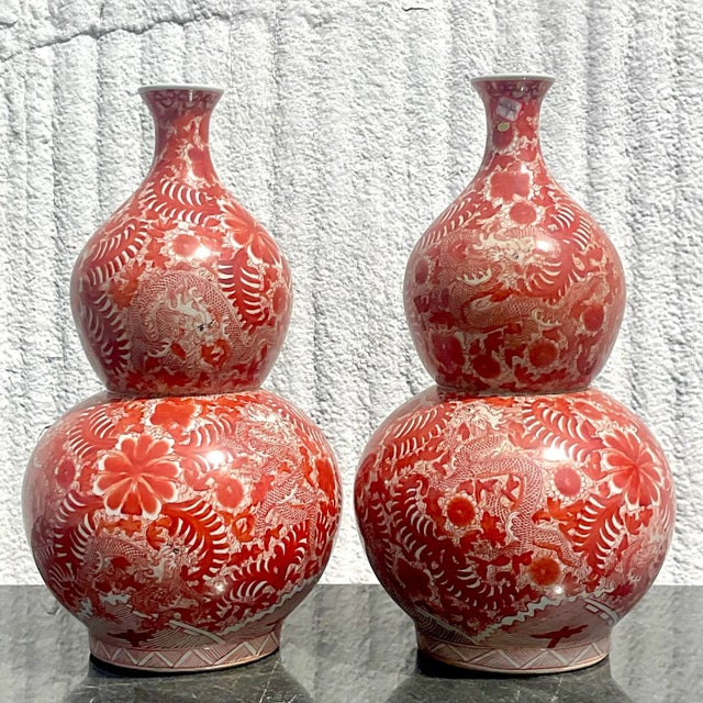 A pair of fabulous vintage Asian vases. This pair of Asian vases are in a beautiful shade of red with amazing details of...