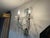 A charming pair of highly decorative three-light wall sconces featuring scrolling metal arms embellished with clear...