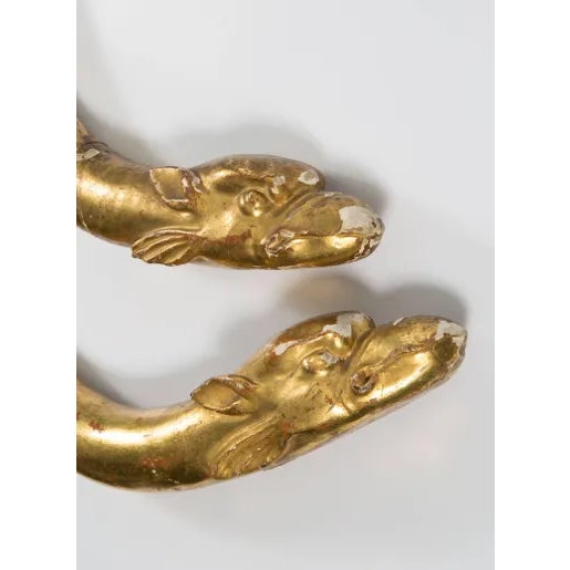 The is a pair of 18th century gold leaf dolphin shaped ornaments. They look interesting laying on a table for decoration...