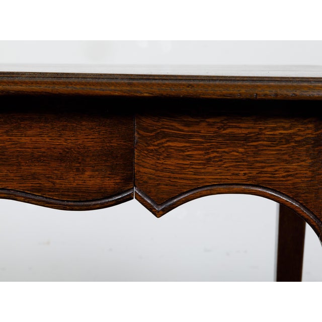 A French Louis XV style oak side table from circa 1900 with single drawer, scalloped apron, curving legs and scrolling...
