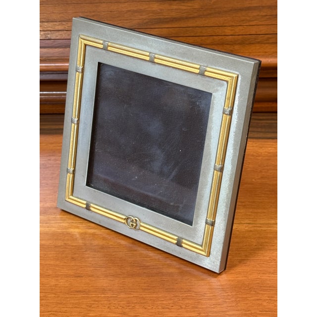 A sophisticated vintage picture frame by Gucci, crafted in Italy during the 1980s. This square frame showcases a refined...