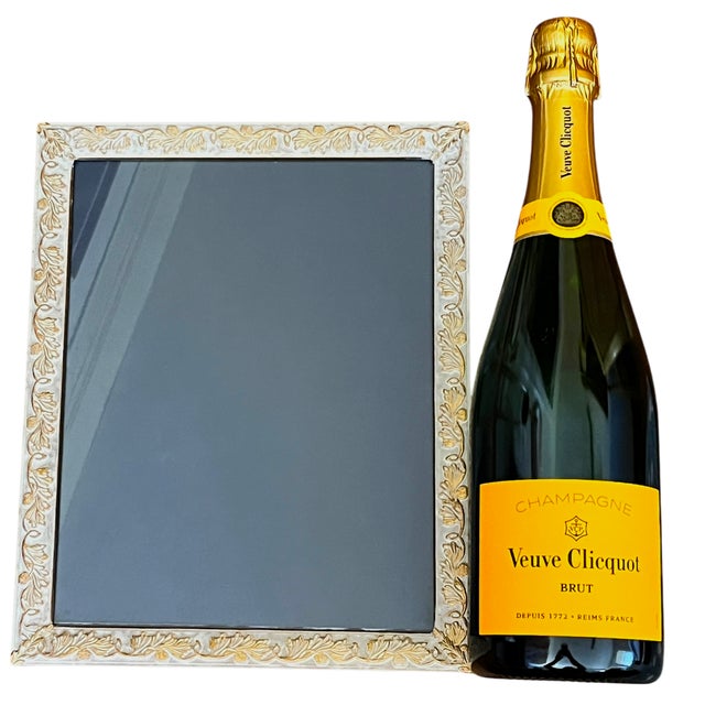 An elegant vintage brass picture frame with an unusual ivory-colored finish and warm gold detailing. The wide border is...