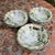 An elegant set of six ornate porcelain bowls, with a hand painted lovely floral pattern in soft pink and greens. They are...