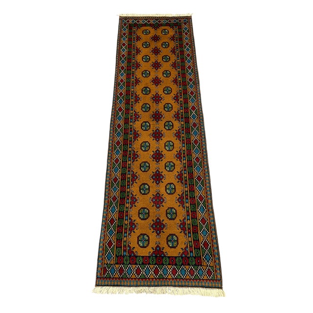 This Mori Gul runner pairs a rich mustard-gold field with two orderly rows of small octagonal guls and repeating red...