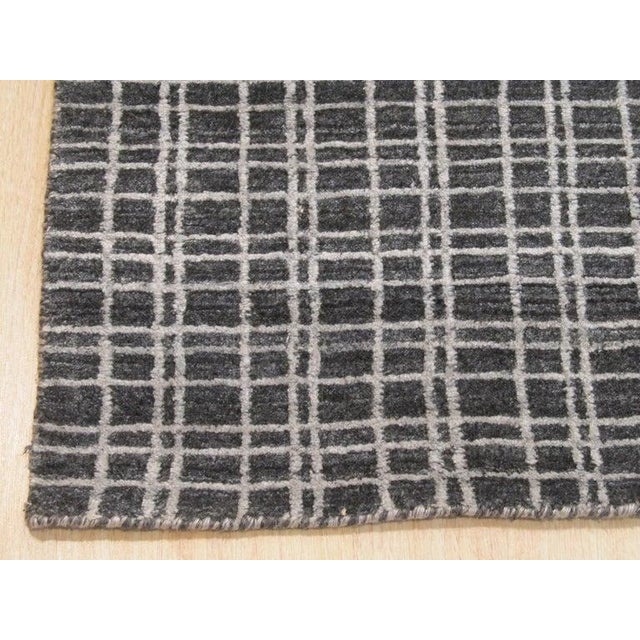 This hand knotted pile rug features a primary gray color and is constructed from bamboo silk. The rug adheres to the EORC...