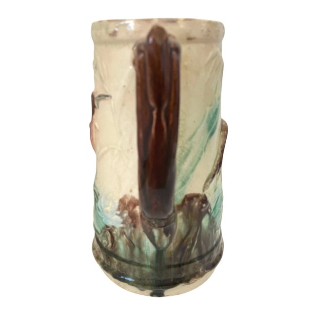 This antique Majolica pitcher features a beautiful crane and lily pad design in a vibrant multi-color pattern. The round...