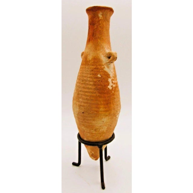 Ancient Terracotta Elongated Piriform Body Transport Amphora on Stand Measures 2 1/4 diameter and 6 3/4" tall. This object...
