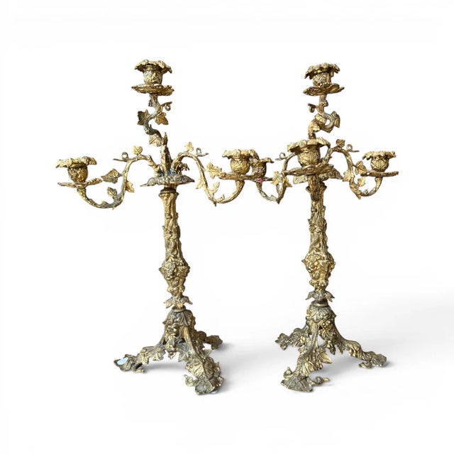 A distinguished pair of early 20th-century bronze candelabras showcasing elegant craftsmanship and a richly developed...