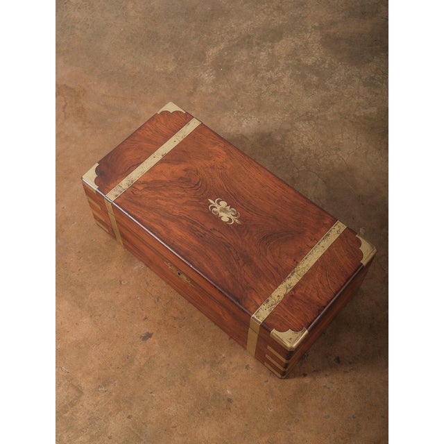 A striking vintage brass-bound writing slope crafted in richly figured rosewood with elegant brass corner mounts and...