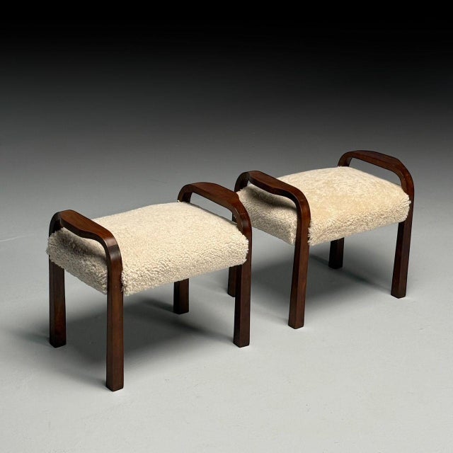 Italian Mid-Century Modern, Footstools or Ottomans, Beige Sheepskin, Mahogany, Italy, 1950s A pair of Italian modernist...