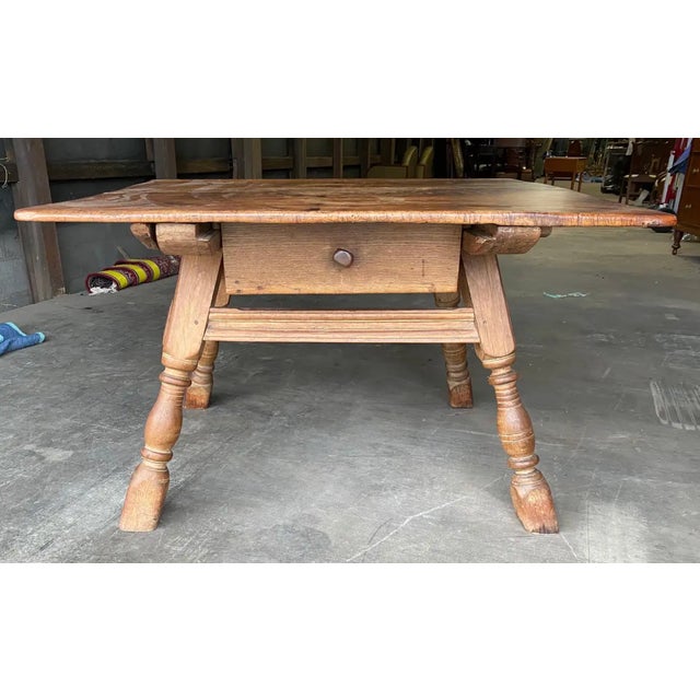 19th-century Swedish oak table with drawer and scrolled apron.