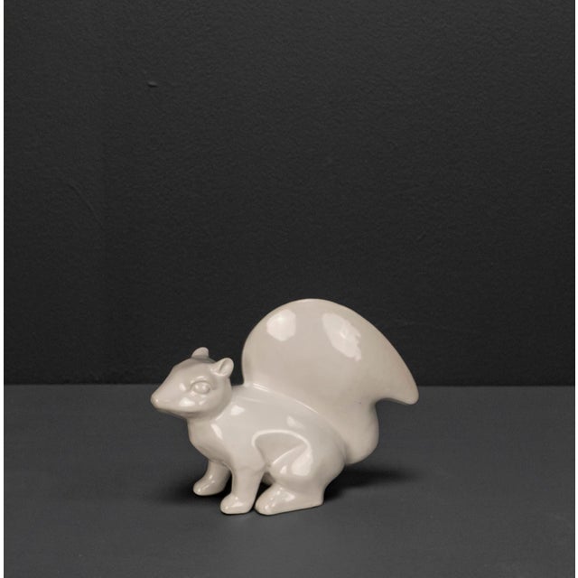 This white glazed stoneware squirrel is a decorative vintage object from the 1960s that impresses with its beautiful shape...