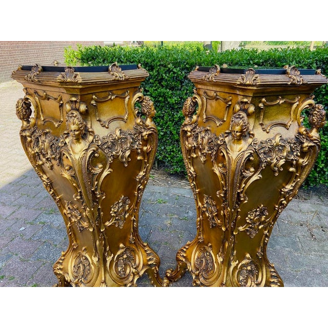 A dramatic pair of 1980 Italian Baroque-style pedestals, crafted in high-quality resin with an antique gold finish and...