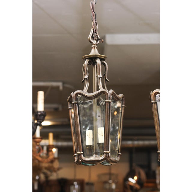 A striking pair of bronze-finished lantern pendants with flowing frames and softly bowed glass panels. The art Nouveau...