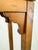 A charming vintage wooden pedestal stand featuring a warm honey-brown finish and a tall, slender silhouette. The square...