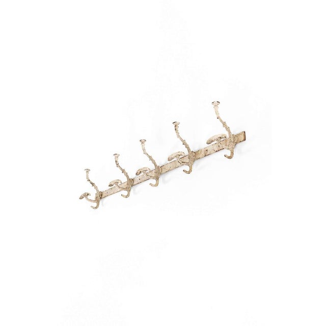 An charming run of late Victorian iron hooks with an arrangement of five shapely hooks along a back support. The hooks are...