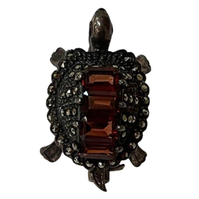 This is a sterling silver turtle brooch with marcasites and amethyst-type stones. It has a locking pin on the back to keep...