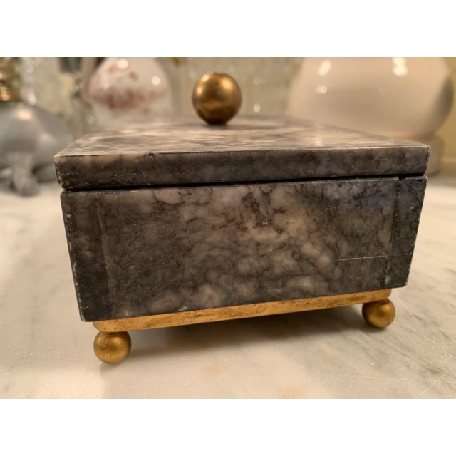 Here we have a very pretty matte gray marble box mounted on darling gold metal ball feet with a matching gold ball finial...