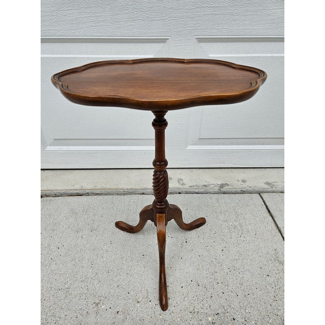 This diminutive mahogany oval side table with turned pedestal base and tripod stand is by Brandt. The table has a...