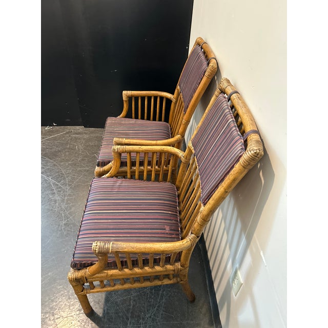 Vintage Henredon bamboo-style captain’s dining chair with rattan frame and striped cushion. Features barrel-style arms and...