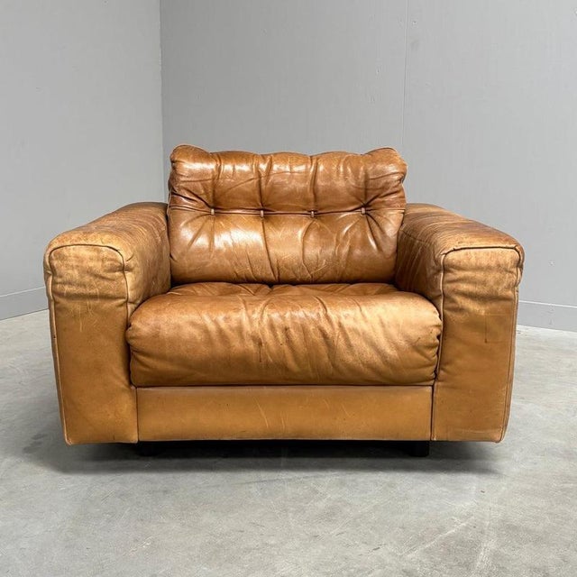 Mid century lounge chair by De Sede. Design by Robert Haussmann, Switzerland 1970s. Wooden frame with cognac leather...