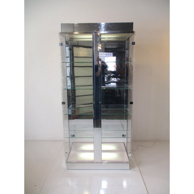 A very well crafted display cabinet in Lucite , glass and chromed Lucite with four non adjustable glass shelves . The top...