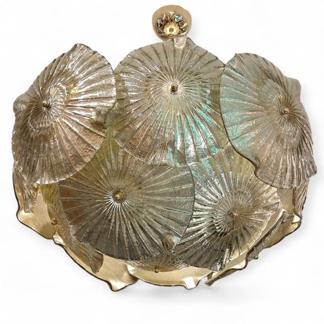 Lamp crafted from Murano glass. Its design features a hemisphere of water lilies in golden tones. Each of the golden discs...