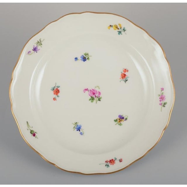 Meissen, Germany. Four porcelain plates. Hand-painted with polychrome floral motifs, gold rim. Approximately 1920s/1930s....