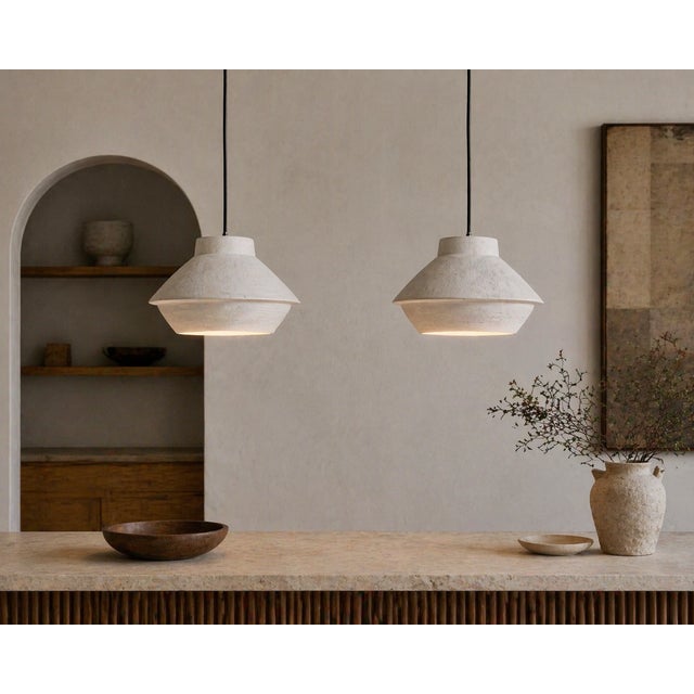 A pair of handcrafted ceramic pendant lights by Miri Mara, a California-based studio known for its refined, material-...
