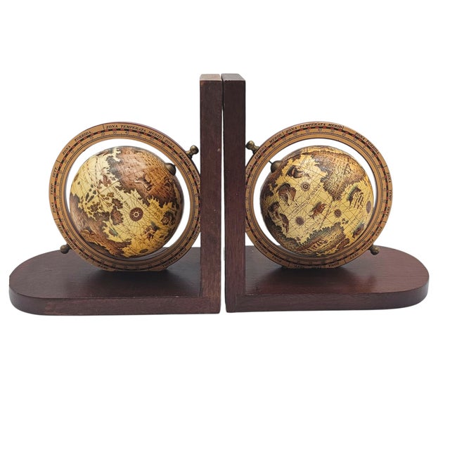 Two tiny worlds spin between wooden walls, as if holding centuries of voyages within their orbits. The brass details gleam...