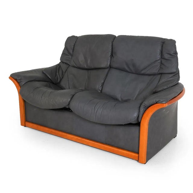 An Ekornes (label attached) Eldorado Stressless leather loveseat. The sofa is well made and allows for reclining...