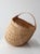This sculptural vintage wicker buttocks basket features a rounded handwoven form, open lattice weave, and a bentwood...