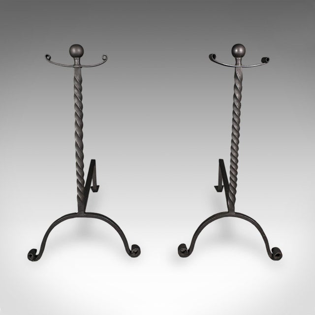 This is a large pair of antique fireplace andirons. An English, wrought iron fire dog, dating to the Victorian period,...