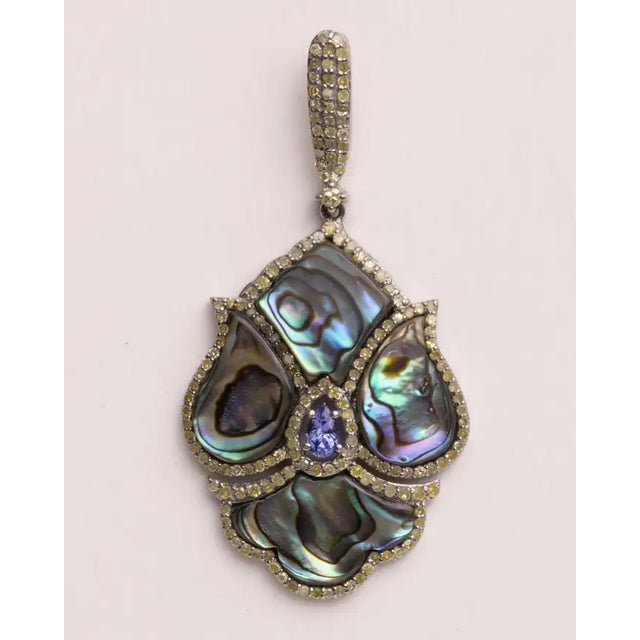 An amazing and unusual pair of dangle drop earrings featuring slices of abalone shell bordered with pave`-set, round,...