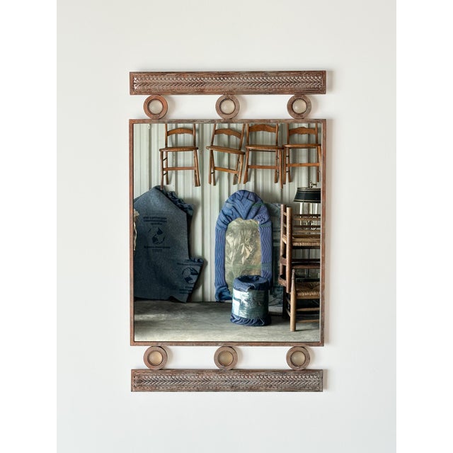 Crafted from steel and finished in a richly distressed copper-bronze patina, this vintage wall mirror is framed top and...