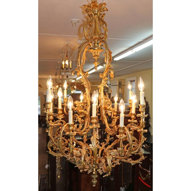 Early 20th Century French Rococo Style Gilt Bronze Putti 16 Light Chandelier Dimensions : 52" Tall X 35" Wide X 35" Deep...