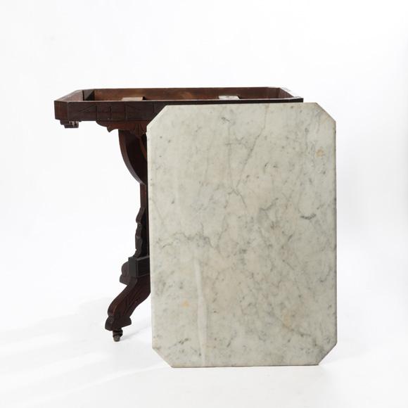 19th century walnut Victorian Eastlake marble top table with original finish and casters.