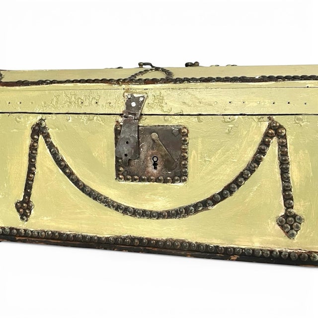 A nicely decorated antique wood trunk or chest of petite size. The wood is painted a dusty green and extensively adorned...