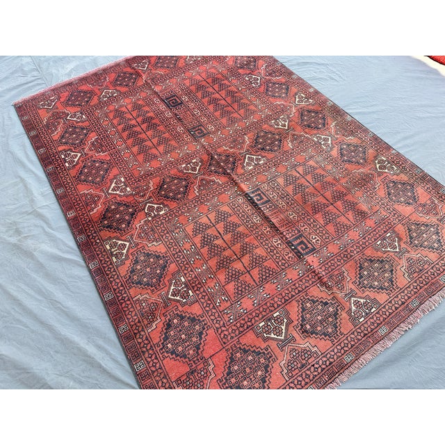 This hand-knotted Baluch rug features two paneled compartments of dense diamond lattice in deep navy, divided by a meander...