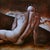 The painting features a solitary figure in a contemplative pose, with a strong emphasis on the curvature of the back and...