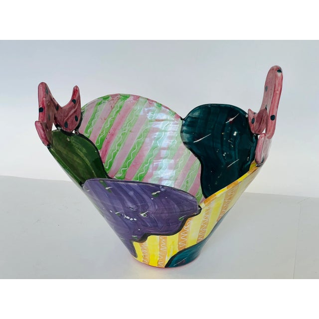 Hand made artistic bowl with bright colors and unusual design. There are two abstract handles and the interior looks like...
