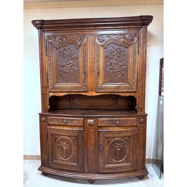 18th century Alsatian buffet in walnut. Front opening with 4 leaves and 2 drawers. Carved decorations of flower baskets...