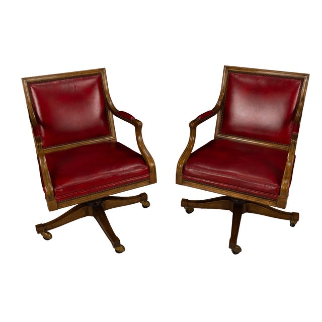 A pair of Baker rolling office chairs with a more classic, tailored feel. Solid wood frames with carved arms, brass...