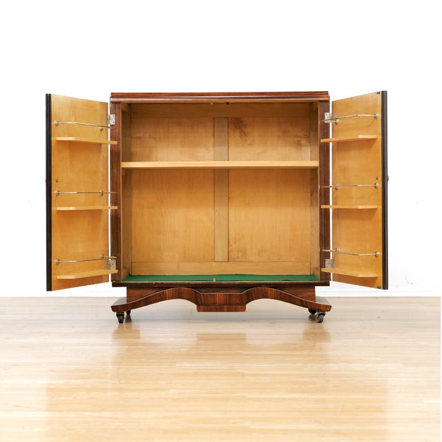 A striking vintage cocktail cabinet finished in richly figured rosewood veneer with dramatic book matched grain...