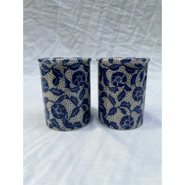 A matching pair of round porcelain salt and pepper shakers with blue floral decoration.
