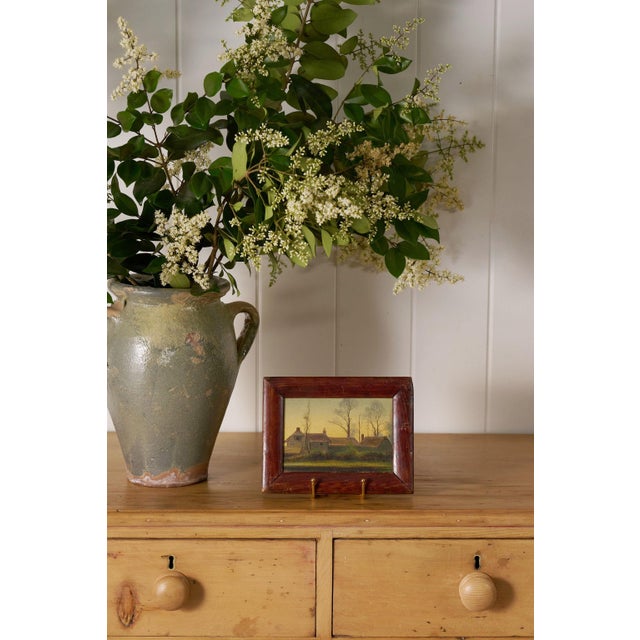 Original petite oil painting on board depicting a village landscape with houses. Executed in warm, muted tones with...