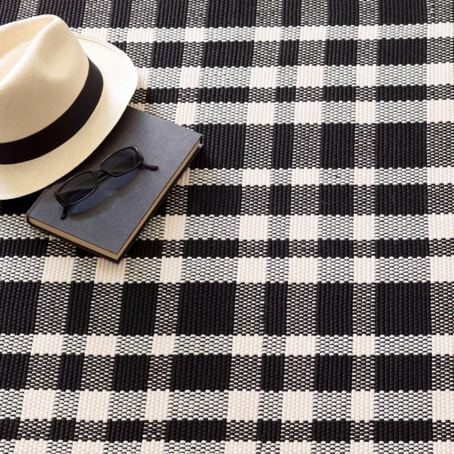 Flat woven, low profile rug in a crisply contrasting Black and White plaid is made of durable polypropylene is soft...